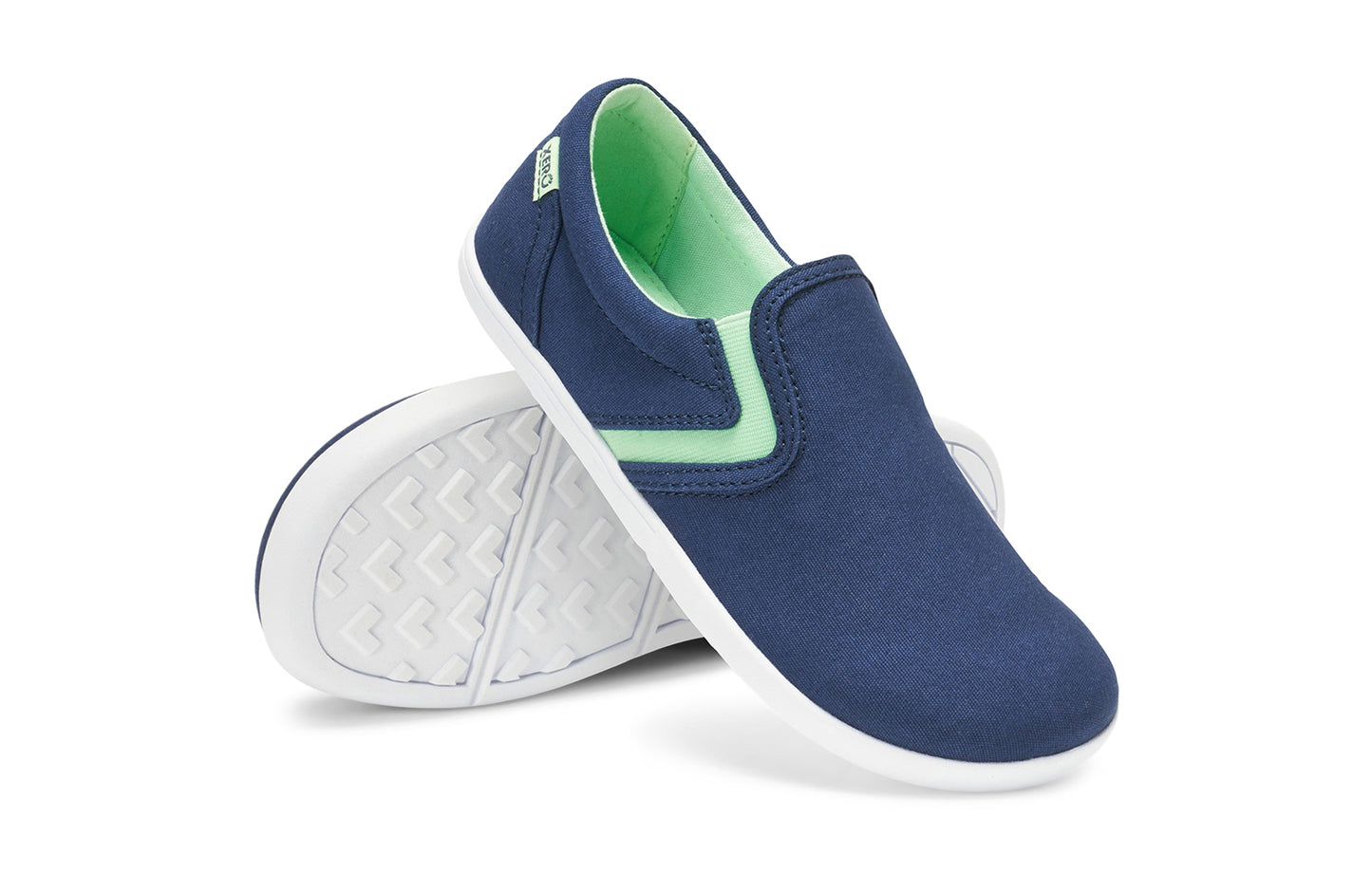 Xero Kid's Barefoot Shoes sold in Ontario, Canada. These minimalist shoes have flexible soles, wide toe boxes, and zero drop. Angled pair view of Xero Youth Dillon Canvas Slip-On in Insignia Blue.