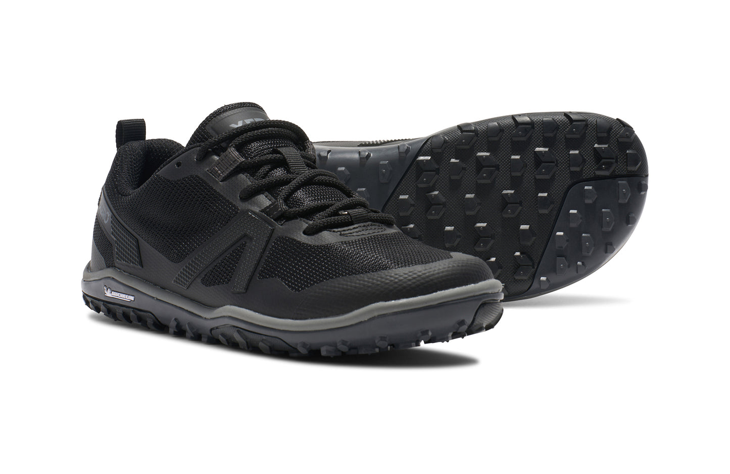 Xero Barefoot Shoes sold in Ontario, Canada. These minimalist shoes have flexible soles, wide toe boxes, and zero drop. Side and sole view of Xero Women's Scrambler Low EV in Black/Steel Gray, a lightweight high-performance trail runner