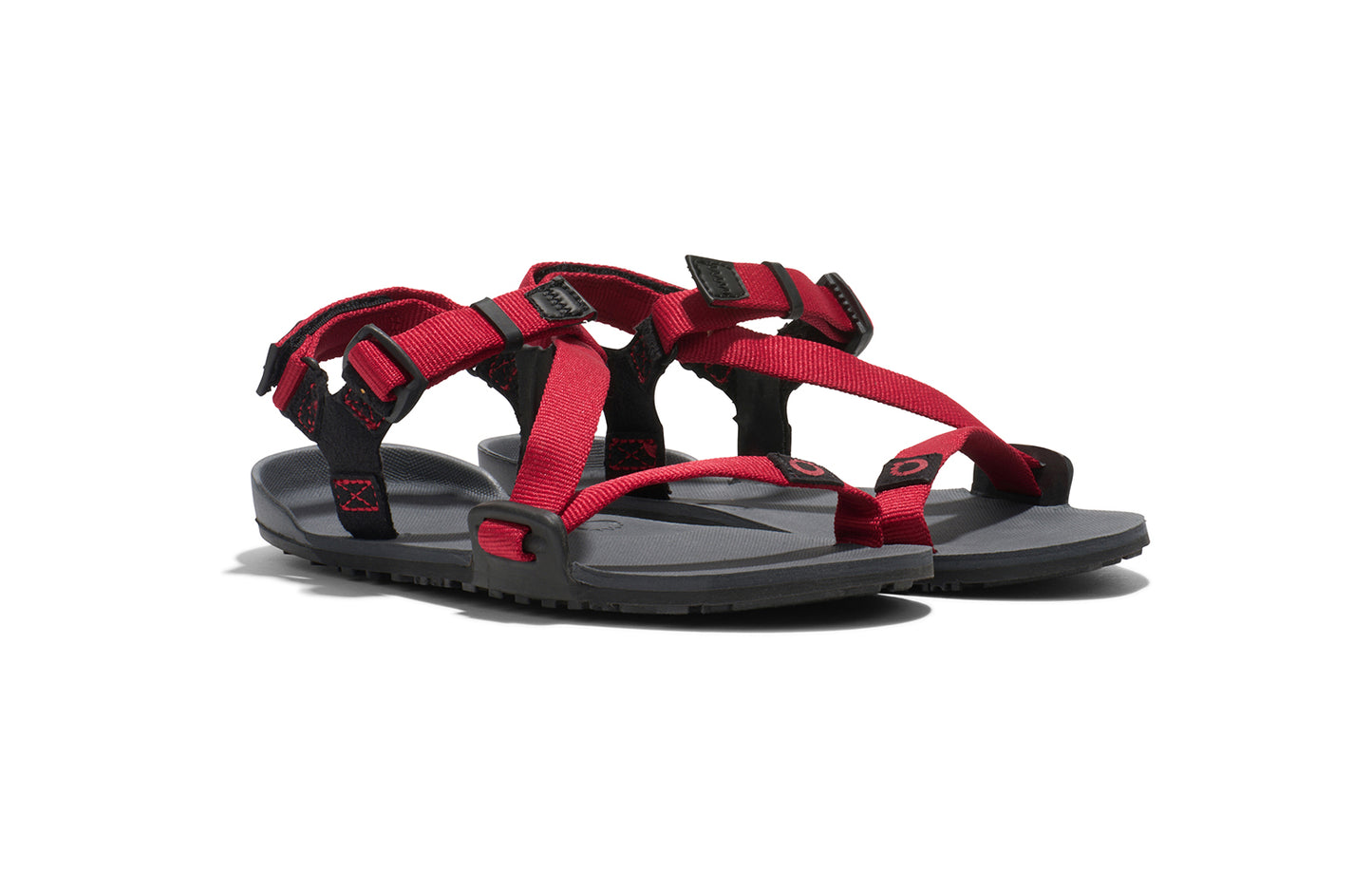Xero Kid's Barefoot Shoes sold in Ontario, Canada. These minimalist shoes have flexible soles, wide toe boxes, and zero drop. Angled view of Xero Kid's Z-Trail in Charcoal/Red Pepper, a lightweight packable sport sandal.
