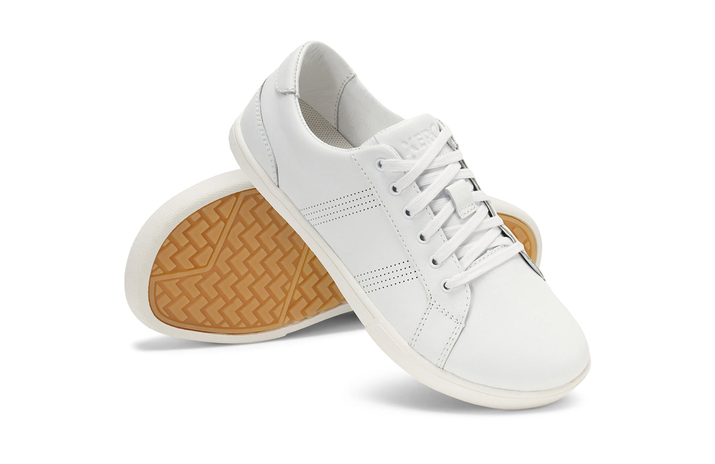 Xero Shoes Canada, specifically women’s barefoot shoes Canada. These minimalist shoes have flexible soles, wide toe boxes, and zero drop. Angled pair view of Women's Dillon Leather in White. A classic leather sneaker.