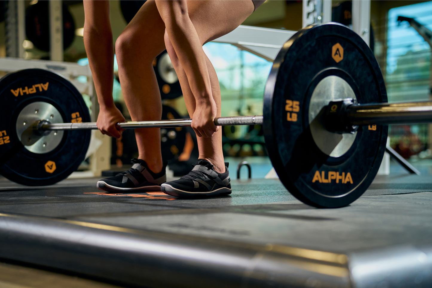 Xero Shoes Canada, specifically barefoot running shoes Canada. Woman weight lifting while wearing Forza Trainer Black