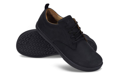Xero Shoes Canada, specifically men’s barefoot shoes Canada. These minimalist shoes have flexible soles, wide toe boxes, and zero drop. Angled pair view of Xero Men's Glenn in Black. Dress casual leather shoe. 