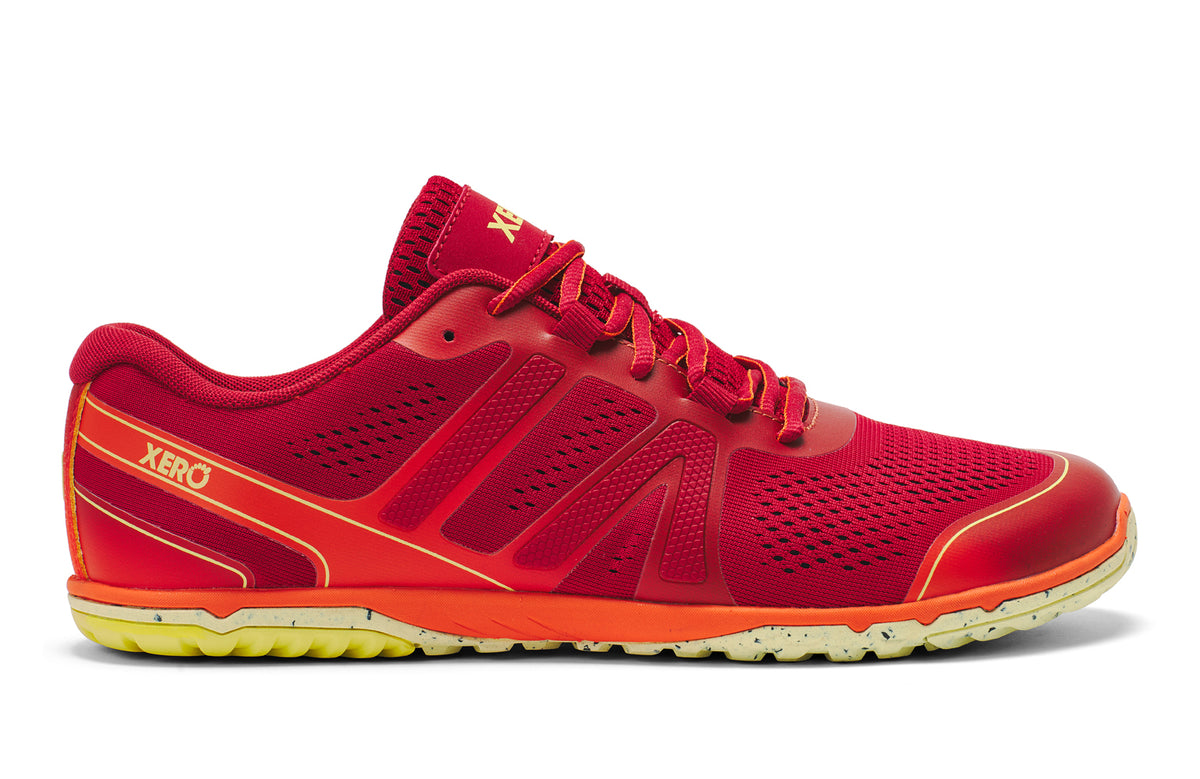Red athletic shoe with orange sole on a white background.  Tru Stride Co brings Xero Shoes to Canada