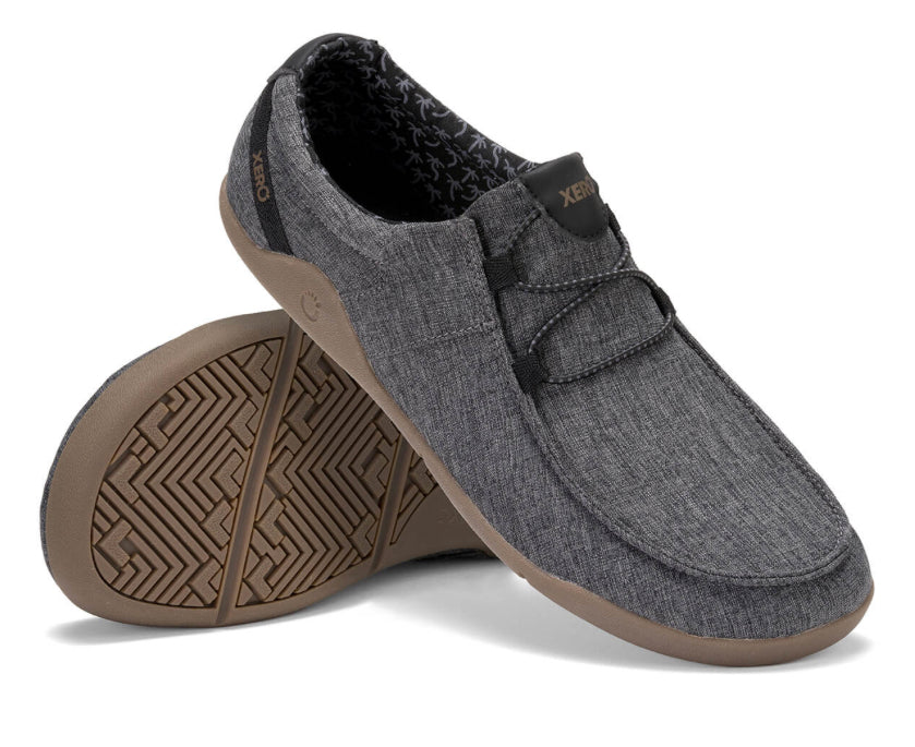 Xero Shoes Canada, specifically men’s barefoot shoes Canada. These minimalist shoes have flexible soles, wide toe boxes, and zero drop. Angled pair view of Xero Men's Kona in Asphalt. Moccasin inspired casual shoe. 
