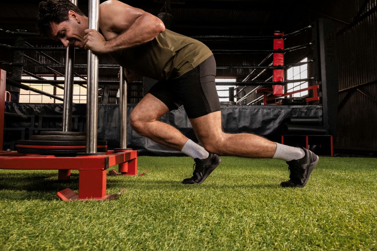 Person performing a lunge exercise in an indoor sports facility. Tru Stride Co brings Xero Shoes to Canada
