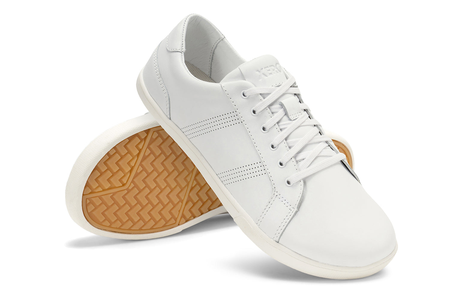 Xero Shoes Canada, specifically men’s barefoot shoes Canada. These minimalist shoes have flexible soles, wide toe boxes, and zero drop. Angled pair view of Men's Dillon Leather in White. A classic leather sneaker. 