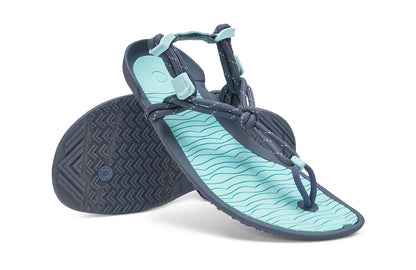 Xero Shoes Canada, specifically women’s barefoot shoes Canada. These minimalist shoes have flexible soles, wide toe boxes, and zero drop. Angled pair view of Xero Women's Aqua Cloud in Blue Glow. Versatile water sport and hiking sandal. 