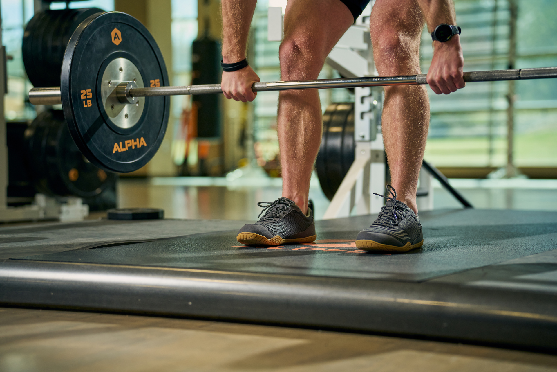 Xero shoes Canada, a barefoot running shoe Canada. Man lifting weight while wearing Xero 360 shoes. 