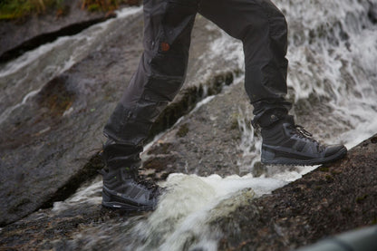 Xero Shoes Canada, specifically barefoot hiking shoes Canada. Man wearing Scrambler Mid while climbing wet rocks