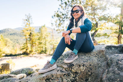 Xero Shoes Canada, specifically barefoot hiking shoes Canada. Woman wearing Scrambler Trail while sitting on a rock in nature