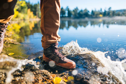 Xero Shoes Canada, specifically barefoot hiking shoes Canada. Man wearing Scrambler Trail Mid WP at the edge of a lake
